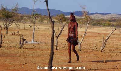 Jeune fille Himba allant vers le Kraal